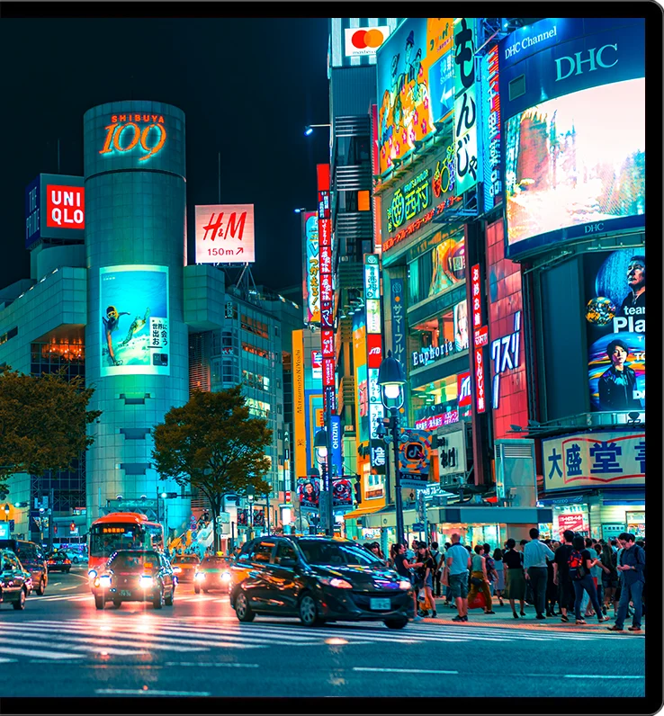 Night street scene with bright neon signs displayed in HDR on a Kuycon monitor