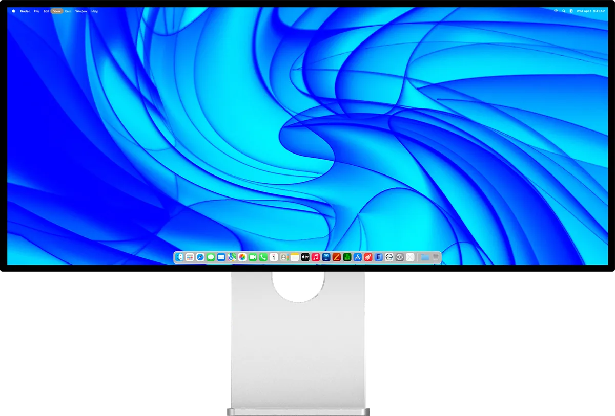 Front view of the Kuycon W34KB ultrawide monitor on its aluminum stand, showing the macOS desktop on a blue wallpaper